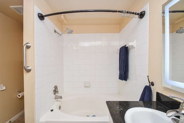 bathroom with vanity and tiled shower / bath