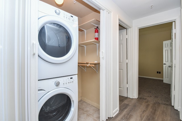 laundry room featuring hardwood / wood-style floors and stacked washer and clothes dryer