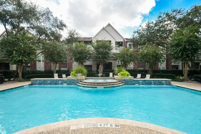 view of pool featuring a hot tub and pool water feature