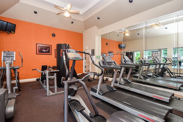 workout area with ceiling fan and a raised ceiling