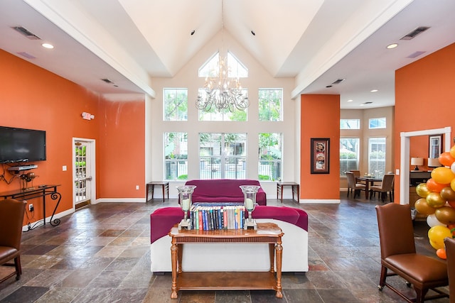 living room featuring high vaulted ceiling, a notable chandelier, and a healthy amount of sunlight