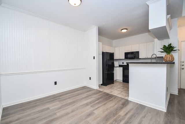 kitchen featuring black appliances, sink, light hardwood / wood-style floors, white cabinets, and kitchen peninsula