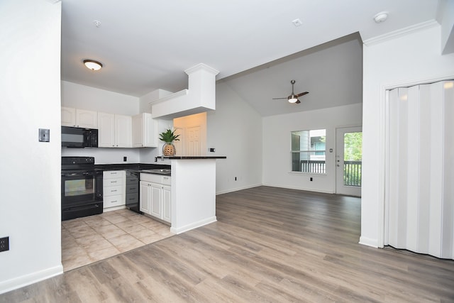 kitchen featuring black appliances, kitchen peninsula, light hardwood / wood-style flooring, lofted ceiling, and white cabinets