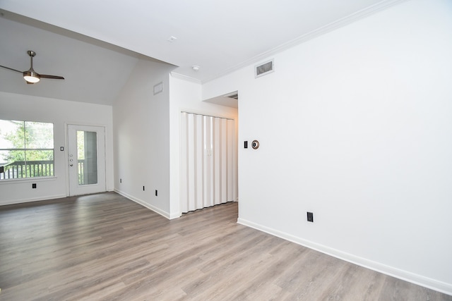 spare room with ceiling fan, vaulted ceiling, light hardwood / wood-style floors, and crown molding