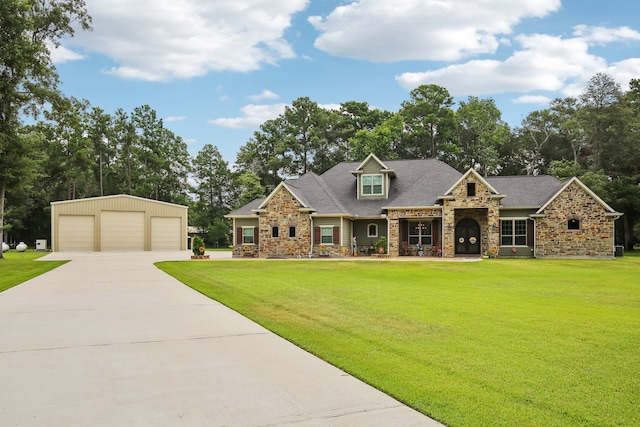 view of front facade featuring a garage, an outdoor structure, and a front lawn