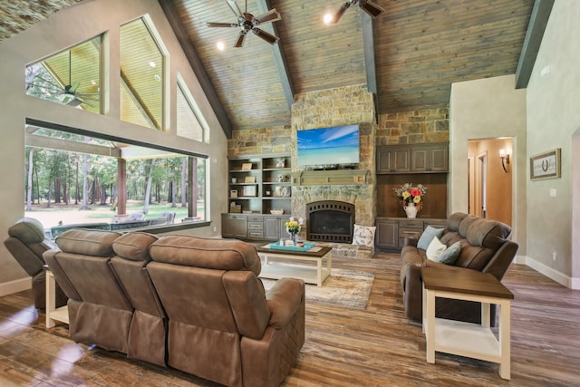 living room featuring hardwood / wood-style flooring, built in features, high vaulted ceiling, wooden ceiling, and a stone fireplace