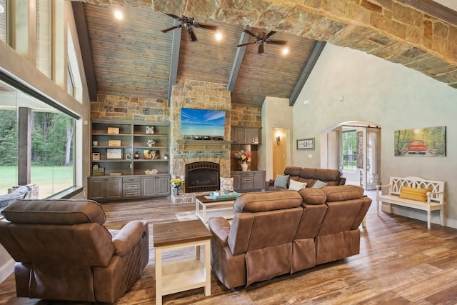 living room featuring hardwood / wood-style floors, high vaulted ceiling, a fireplace, beam ceiling, and wood ceiling