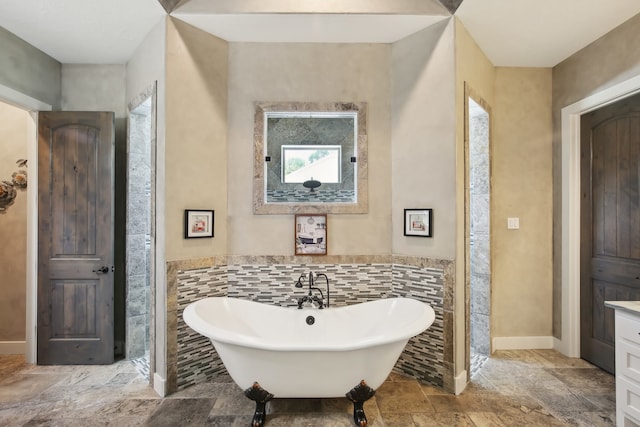 bathroom with vanity, a bathtub, and tile walls