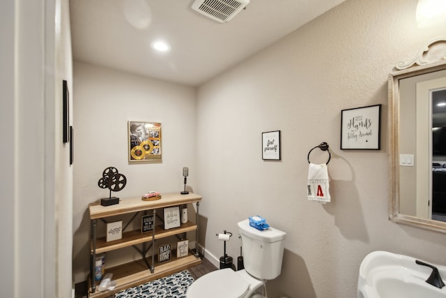 bathroom featuring hardwood / wood-style floors and toilet