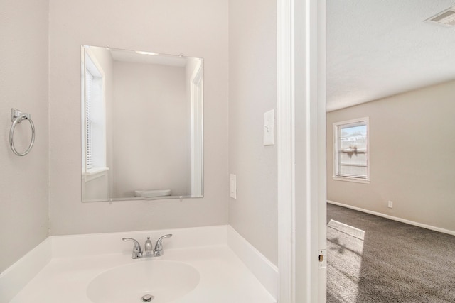 bathroom featuring toilet, a textured ceiling, and sink