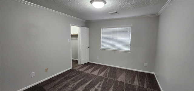 carpeted empty room featuring ornamental molding and a textured ceiling