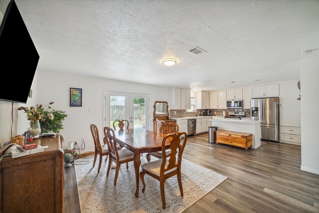 dining space with french doors, a textured ceiling, and dark hardwood / wood-style floors