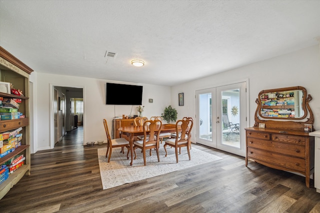 dining area featuring french doors, a textured ceiling, and dark wood-type flooring