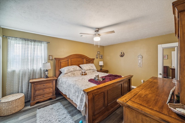 bedroom with ceiling fan, a textured ceiling, and dark hardwood / wood-style flooring