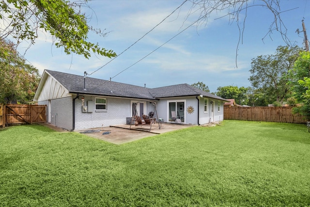 rear view of property featuring a yard and a patio