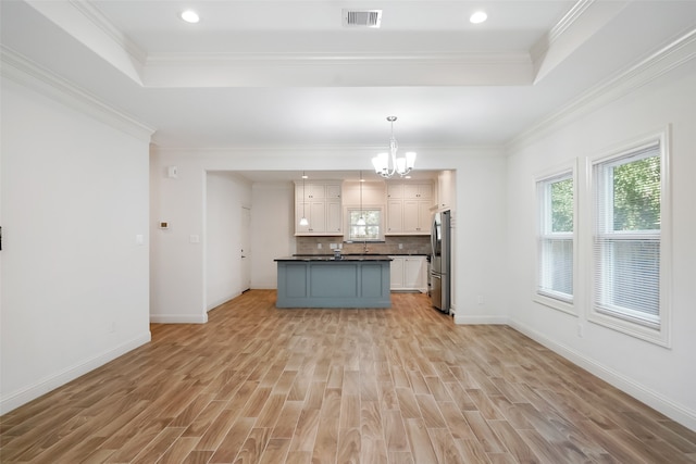 kitchen featuring white cabinets, stainless steel fridge, ornamental molding, pendant lighting, and light hardwood / wood-style floors