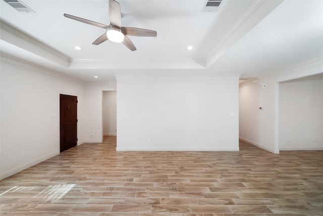 unfurnished room with crown molding, a tray ceiling, light wood-type flooring, and ceiling fan