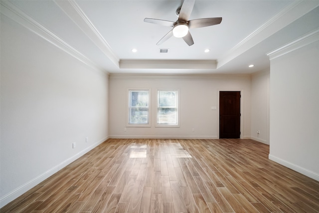 empty room with ceiling fan, light hardwood / wood-style floors, and a raised ceiling