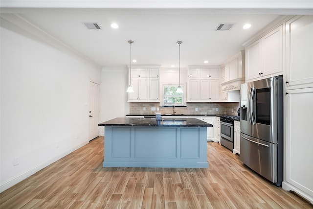 kitchen with stainless steel appliances, decorative light fixtures, a kitchen island, and white cabinets