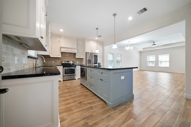 kitchen with sink, a center island, white cabinets, pendant lighting, and appliances with stainless steel finishes