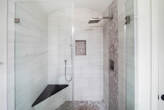 bathroom featuring a shower with door