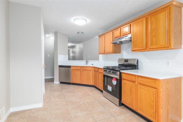 kitchen with appliances with stainless steel finishes, sink, and light tile patterned floors