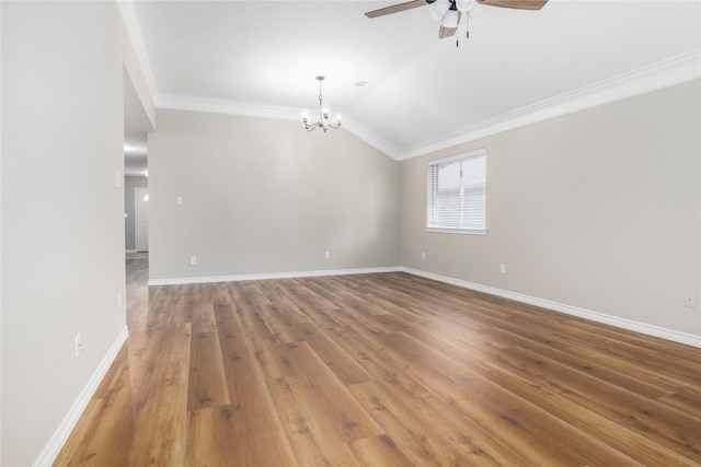 empty room featuring hardwood / wood-style flooring, ornamental molding, lofted ceiling, and ceiling fan with notable chandelier