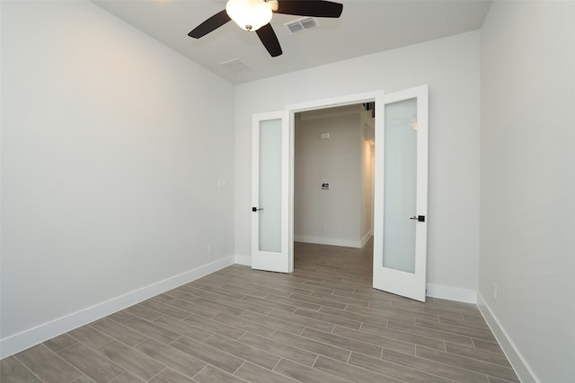 spare room featuring french doors, ceiling fan, and light hardwood / wood-style flooring