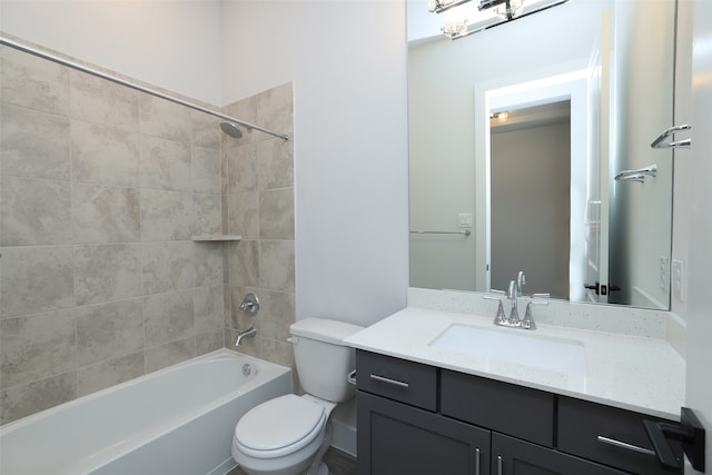 full bathroom with tiled shower / bath, vanity, and toilet