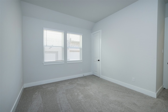 empty room featuring lofted ceiling and light carpet