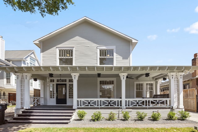 back of house featuring ceiling fan and a porch