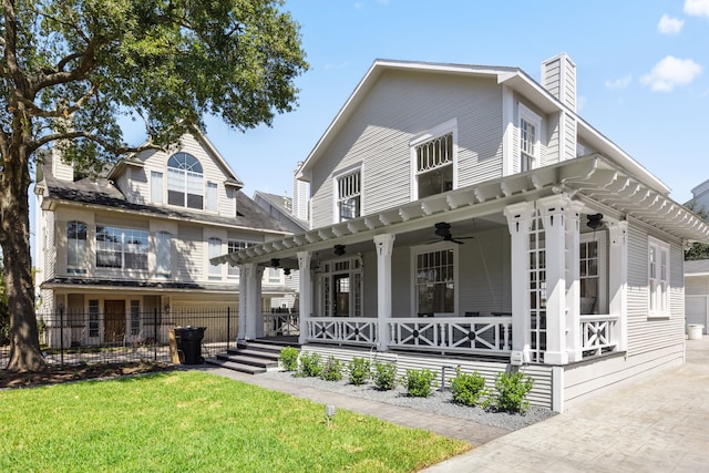 view of front of house with a front yard, a porch, and ceiling fan