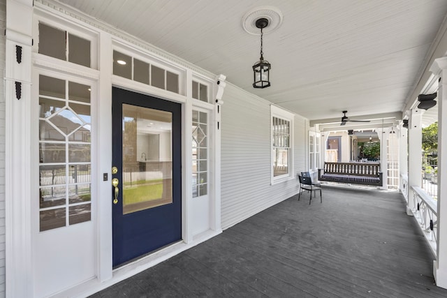 wooden deck featuring covered porch and ceiling fan