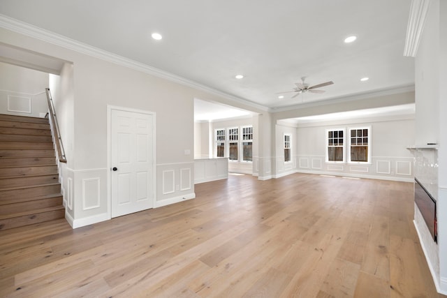 unfurnished living room featuring light hardwood / wood-style flooring, ceiling fan, and crown molding