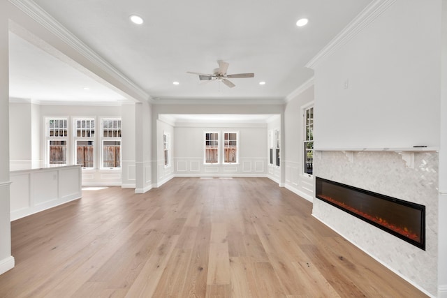 unfurnished living room with ornamental molding, light hardwood / wood-style floors, and ceiling fan