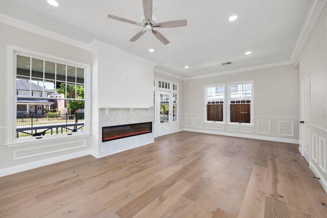 unfurnished living room featuring a wealth of natural light, ornamental molding, light hardwood / wood-style flooring, and ceiling fan