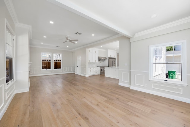 unfurnished living room featuring crown molding, a healthy amount of sunlight, light wood-type flooring, and ceiling fan