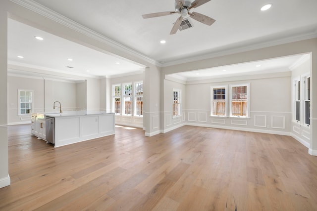 unfurnished living room with crown molding, sink, and light wood-type flooring