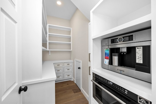 kitchen with dark wood-type flooring, appliances with stainless steel finishes, and white cabinets