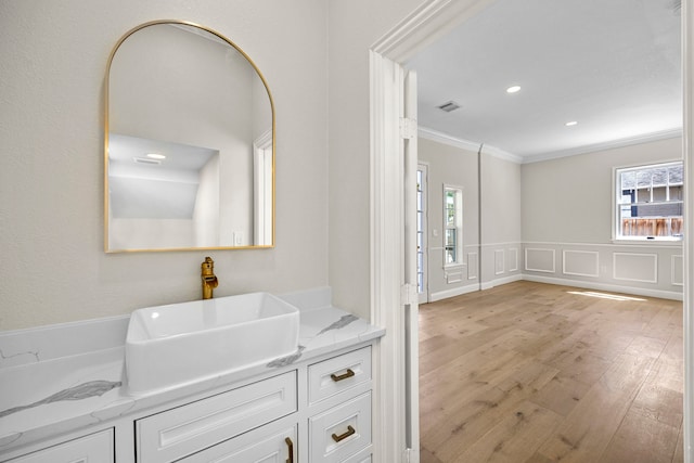 bathroom featuring vanity, ornamental molding, and hardwood / wood-style floors