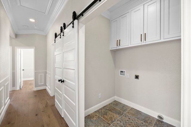 clothes washing area featuring electric dryer hookup, hookup for a washing machine, ornamental molding, hardwood / wood-style floors, and cabinets