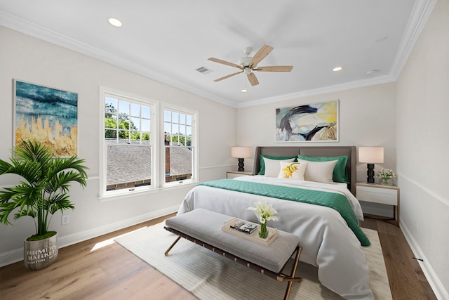 bedroom featuring crown molding, light wood-type flooring, and ceiling fan