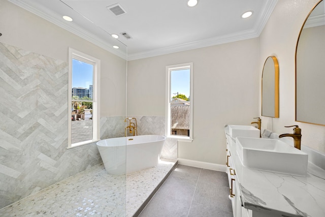 bathroom featuring a tub to relax in, tile patterned flooring, vanity, ornamental molding, and tile walls