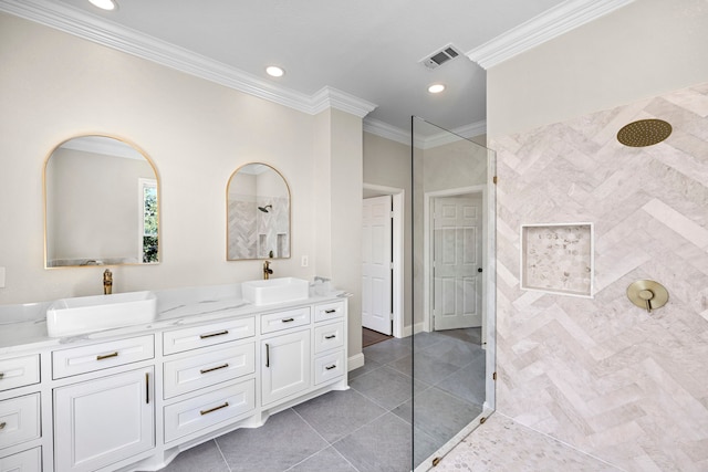 bathroom featuring vanity, crown molding, a tile shower, and tile patterned floors