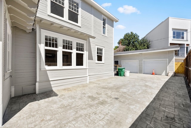 exterior space featuring a patio, a garage, and an outbuilding