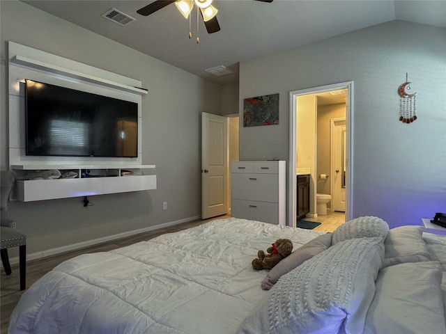 bedroom with ceiling fan, vaulted ceiling, light hardwood / wood-style floors, and ensuite bathroom