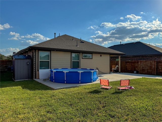 18310 Grayson Bluff Way, Richmond, TX 77407 - back of property with a shed, a patio area, an outbuilding, and a shingled roof