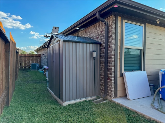 view of side of property featuring a storage unit, a yard, and central AC unit