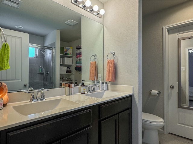 bathroom featuring a shower with door, a textured ceiling, toilet, tile patterned floors, and vanity