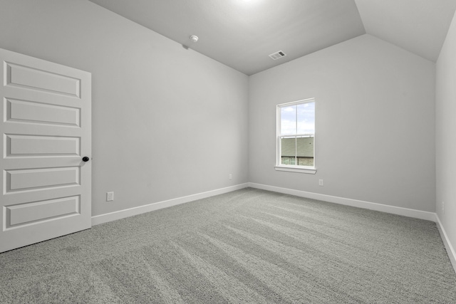 carpeted spare room featuring baseboards, visible vents, and lofted ceiling